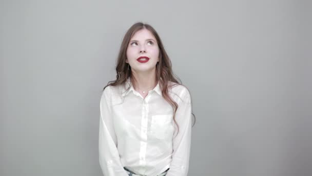Vonzó fiatal nő néz fel, kéz a kézben az arcon, álmodik — Stock videók