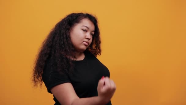 Jeune femme afro-américaine folle avec surpoids montrant le poing à la caméra, se battre — Video