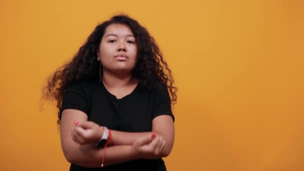 Mujer afroamericana con sobrepeso manteniendo los puños cruzados, mirando a la cámara — Vídeo de stock
