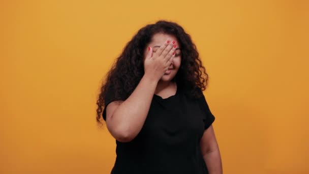 Attraktiv afro-amerikansk kvinna med övervikt täcker öga med hand, ler — Stockvideo