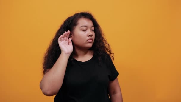 Charmante jeune femme afro-américaine tenant la main sur l'oreille, écoutant quelque chose — Video