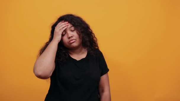 Zmęczona afro-amerykańska młoda kobieta z nadwagą trzymająca rękę na czole — Wideo stockowe