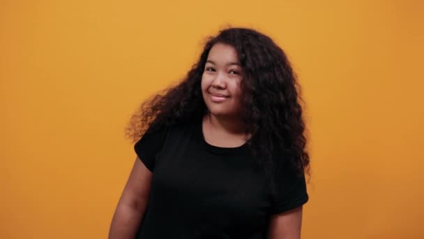Mujer joven afroamericana sonriente con sobrepeso señalando con el dedo a la cámara — Vídeo de stock
