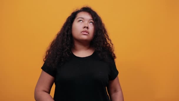 Afroamerykańska młoda kobieta z nadwagą wskazującą palcem w górze, poważna — Wideo stockowe