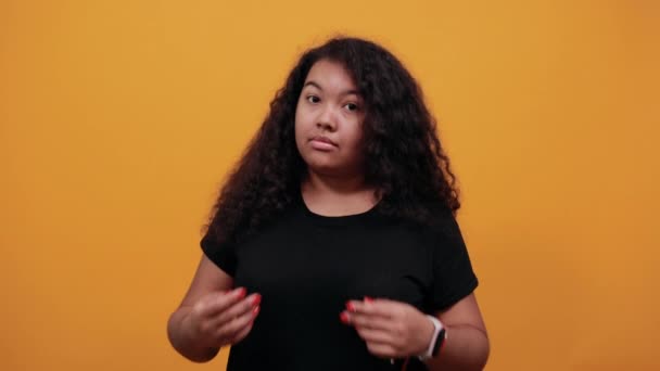 Африкансько-американська молода жінка з надмірною вагою вказівні кулаки на себе — стокове відео