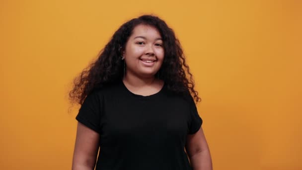 Junge Frau mit Übergewicht zieht Lächeln mit den Fingern und blickt in die Kamera — Stockvideo