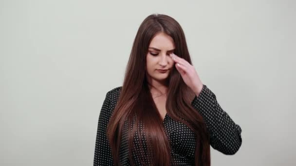 Unhappy young caucasian lady keeping hand on forehead over isolated gray wall — Stock Video