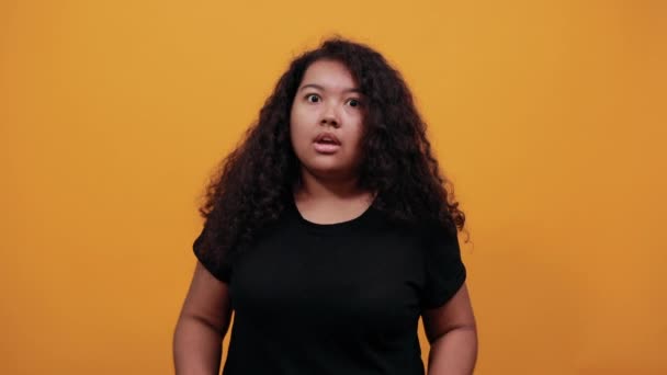 Chockad afro-amerikansk ung kvinna med övervikt täcker munnen med händerna — Stockvideo