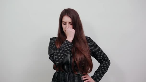Kaukasiska unga kvinna hålla fingret på näsan, klämma den. — Stockvideo