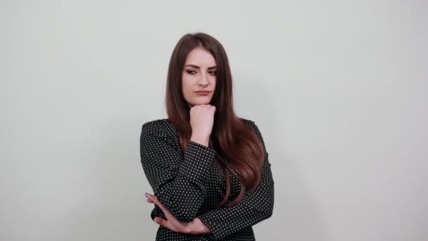 Serious young caucasian lady, keeping hands on chin, looking into distance. — Stock Video