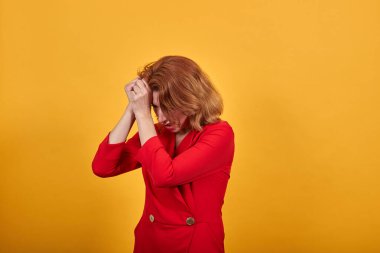 Savunmasız genç kadın ellerini alnında tutuyor, hayal kırıklığına uğramış görünüyor.