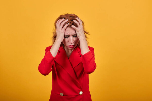 Confused caucasian young woman keeping hand on head, corrects haircut