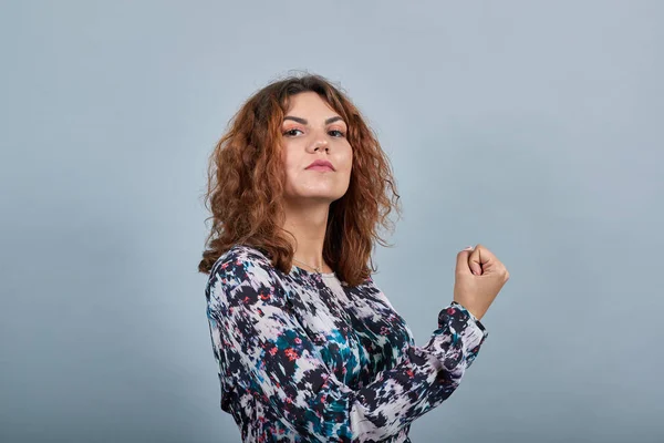 Strenge, charmante junge Dame, die die Faust in die Höhe hält, direkt, stark. — Stockfoto