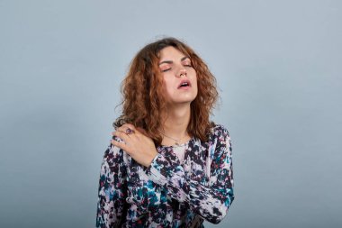 Çekici bir genç bayan ellerini boynuna koyuyor, kaslarında ağrı var..