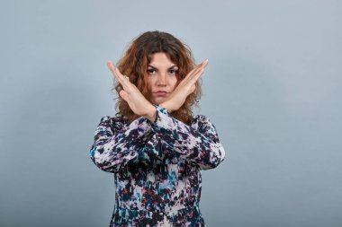 Ciddi genç bayan ellerini çapraz tutuyor, güzel bir yüzük takıyor..