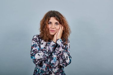 Mutsuz bir bayan, elini yüzüne koyuyor, birbirine tutunuyor, uyku jesti yapıyor.