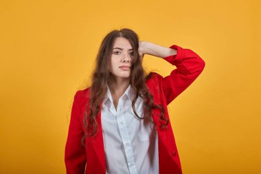 Beyaz gömlekli çekici bir kadın ellerini başının üstüne koyup kameraya bakıyor.