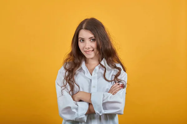 Fröhliche Frau im weißen Hemd, die Hände gekreuzt, in die Kamera blickend, lächelnd — Stockfoto