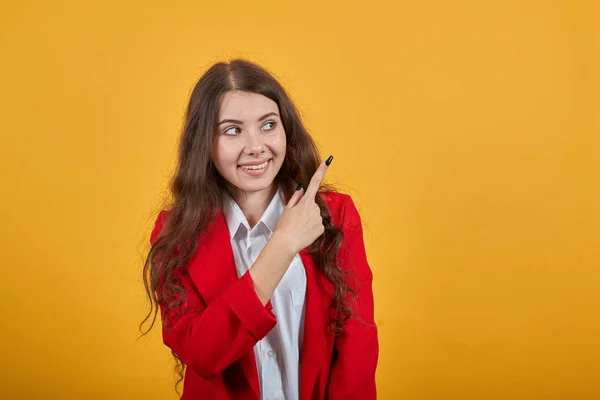 Atractiva joven alegre señalando el dedo detrás de la espalda, sonriendo —  Fotos de Stock