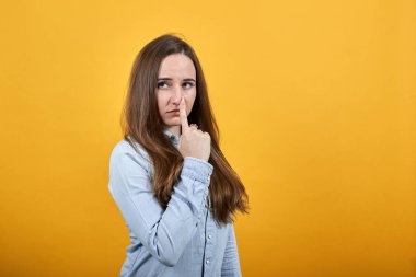 Çekici beyaz kadın, parmaklarını burnuna dayamış, hayal kırıklığına uğramış..