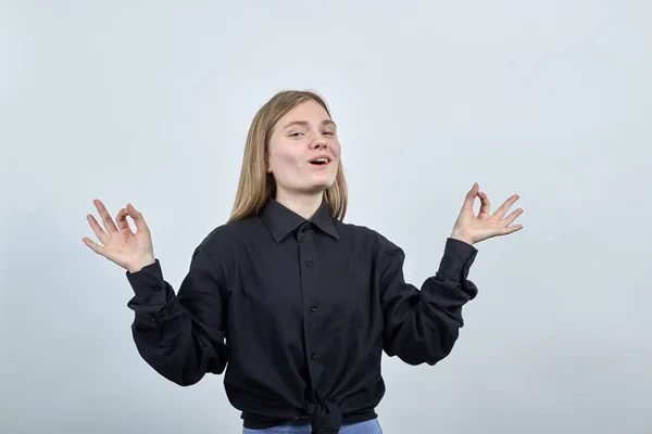 Mulher alegre em camisa preta mantendo os dedos juntos, meditação, relaxar — Fotografia de Stock