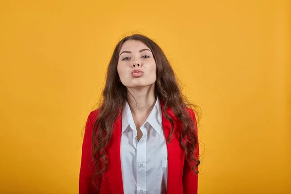 Donna attraente nella moda camicia bianca e giacca rossa che soffia, invia bacio aereo — Foto Stock