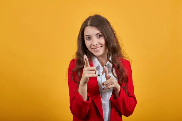 Mujer alegre en camisa y chaqueta roja señalando con los dedos a la cámara, sonriendo —  Fotos de Stock