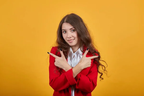 Mujer alegre manteniendo las manos cruzadas, señalando los dedos a un lado, mirando a la cámara , —  Fotos de Stock