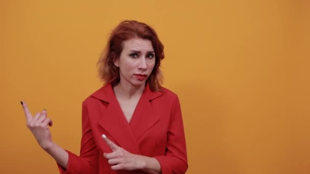 Ernsthafte kaukasische junge Dame zeigt mit dem Finger nach oben und blickt in die Kamera — Stockvideo