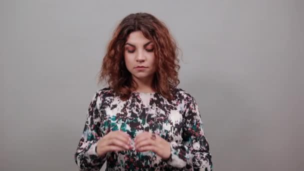 Attraktiv kaukasisk ung kvinna hålla tummar nära ansiktet, ler. — Stockvideo