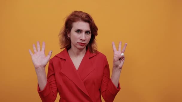 Attraktiv kaukasisk ung kvinna visar åtta fingrar, tittar direkt. — Stockvideo