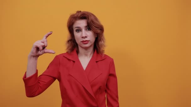 Csalódott fiatal nő tartja a teret az ujjai között, a kamerába néz — Stock videók