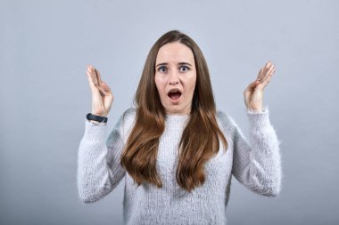 Şaşırmış çekici kadın ellerini açar, ağzını açar ve kameraya bakar..