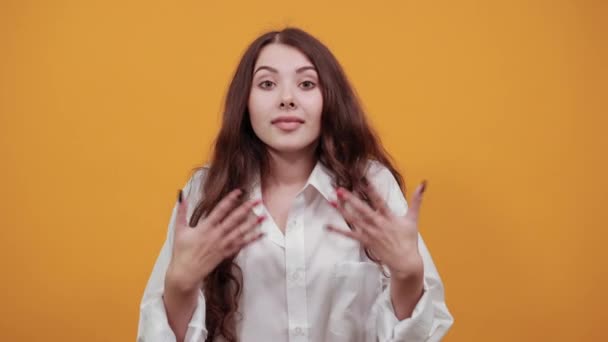 Sonriente mujer caucásica en la moda camisa blanca extiende las manos, se ve sorprendido — Vídeo de stock