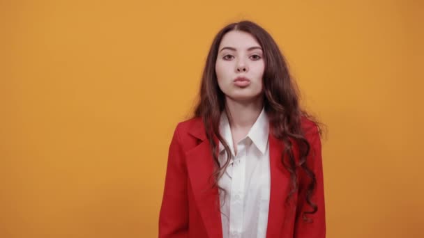 Attractive woman in fashion white shirt and red jacket blowing, send air kiss — Stock Video