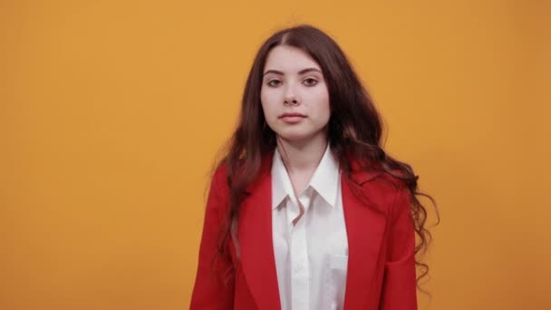 Attractive woman in shirt and red jacket pointing finger behind back, smiling — Stock Video