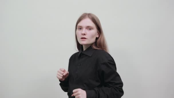 Kavkazská mladá žena v módní černé košili ukazující pěsti na kameru, boj. — Stock video