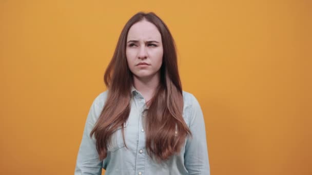 Serieuze brunette vrouw in denim blauw shirt houden vinger op de mond, denken — Stockvideo