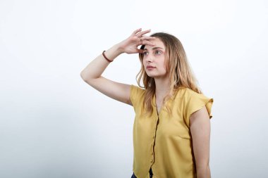 Çekici genç sarışın kadın elini alnına koydu, mesafeye baktı.