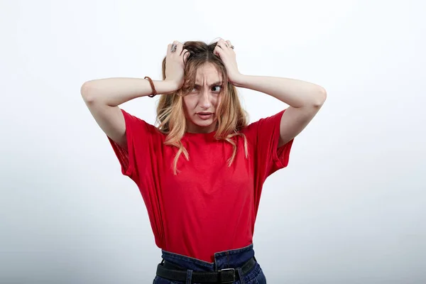 Pazzo donna caucasica nella moda camicia rossa tenendo le mani sulla testa, deluso — Foto Stock