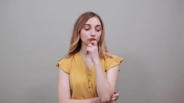 Teleurgestelde vrouw houdt de vinger op kin, denkt na, omhelst zichzelf — Stockvideo