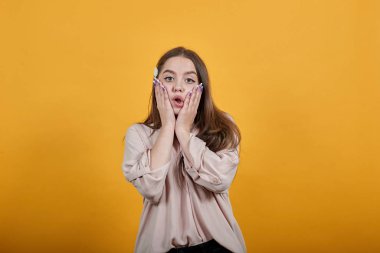 Yorgun, beyaz bir kadın ellerini yanaklarından ayırmıyor, mutsuz.