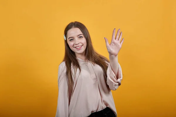 Atractiva joven morena mostrando la palma de la mano en la cámara, saludando, decir hola — Foto de Stock