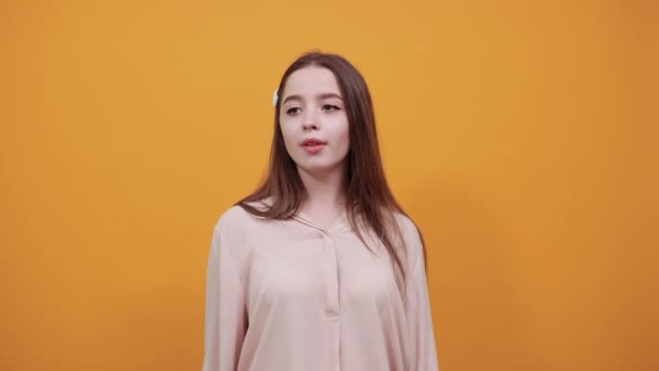 Charmante vrouw in mode pastel shirt doet vorm van hart op camera — Stockvideo