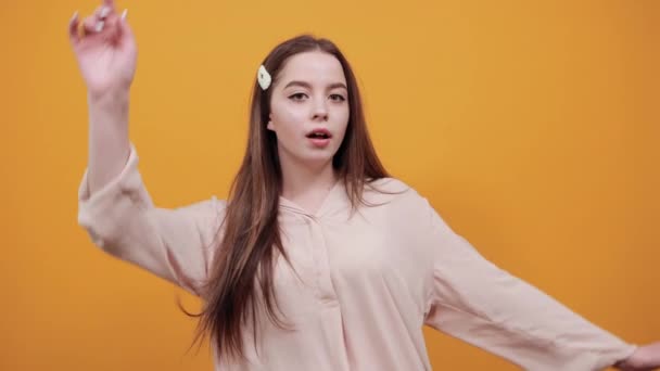 Mujer alegre en camisa de pastel de moda estirada, manteniendo la mano por encima de la cabeza — Vídeo de stock