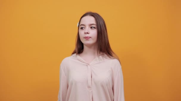 Kalme vrouw in pastelkleurige shirt die de vinger op de mond houdt, stilte, het doen van shh gebaar — Stockvideo