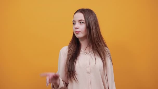 Attractive woman in pastel shirt keeping hands crossed, pointing fingers aside — 图库视频影像