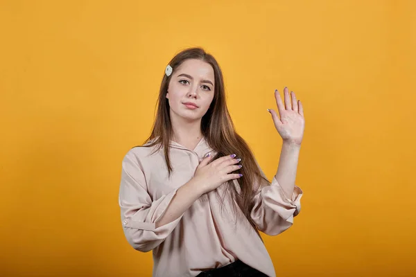 Серйозна жінка тримає руку на грудях, показуючи долоню на камеру, даючи обіцянку — стокове фото