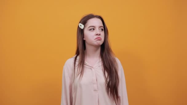Atraktivní mladá žena drží ruku na opasku, drží prst na ústech — Stock video