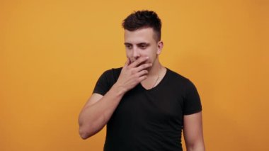 Odaklanmış beyaz adam parmaklarını çenesinde tutuyor, düşünüyor, kameraya bakıyor.